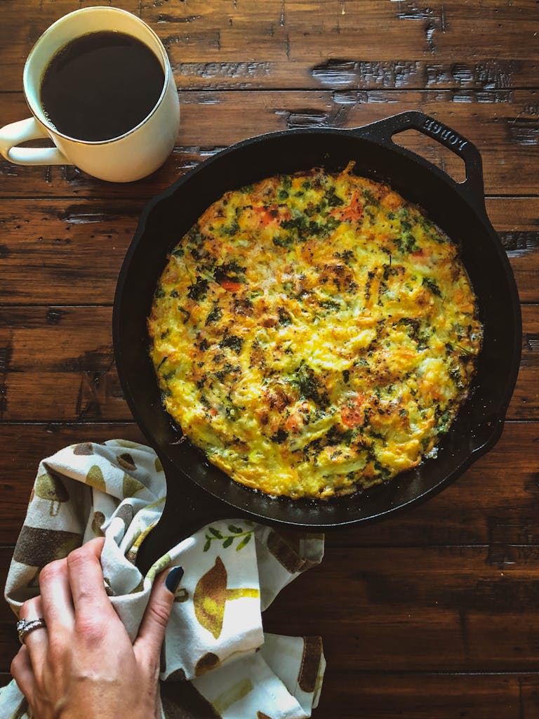 Egg Based Dish With Black Coffee On Wooden Table